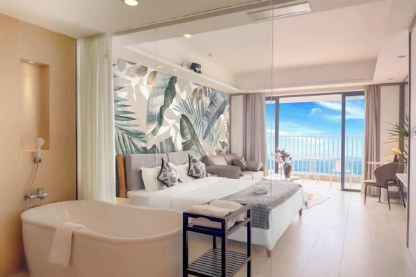 A modern hotel room with a large bed, a bathtub, a balcony with a view, and a tropical-themed wall mural. - Island Skylight Resort (Huidong)