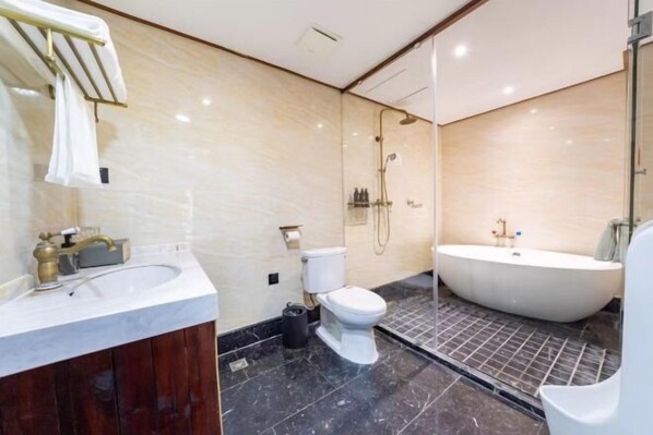 A modern bathroom with a marble sink, toilet, and a freestanding bathtub. - Yongle Inn (Yangzhou)