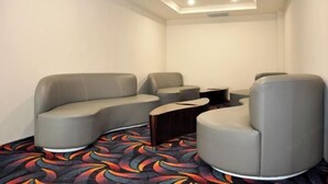 Ein stilvoller Lounge-Bereich mit gebogenen Sitzmöbeln und einem gemusterten Teppich.