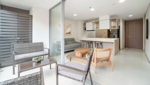 Un apartament modern amb una porta corredissa de vidre que separa el saló de la cuina.