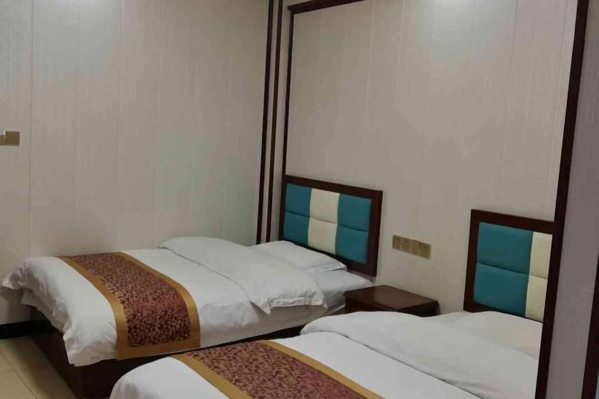 Een hotelkamer met twee bedden, elk met hoofdeinde en nachtkastje.