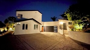 Una casa moderna con el número 2144 en la fachada, un garaje y un camino de entrada.