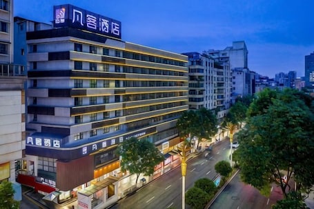 A multi-story hotel with a prominent sign, a street view, and surrounding buildings.. Fanke Hotel (Zunyi Club Site Zhonghua Road)