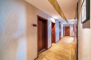 A hotel hallway with wooden doors, a carpeted floor, and a framed picture on the wall. - Fanke Hotel (Zunyi Club Site Zhonghua Road) (Zunyi)