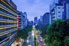 A city street lined with modern buildings, a clear sky, and vehicles on the road. - Fanke Hotel (Zunyi Club Site Zhonghua Road) (Zunyi)
