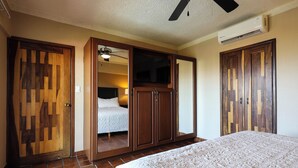 A bedroom with a bed, wardrobe, and a ceiling fan. - A-505 Enjoy Your Vacation In This Charming Condominium! (Cabo San Lucas)