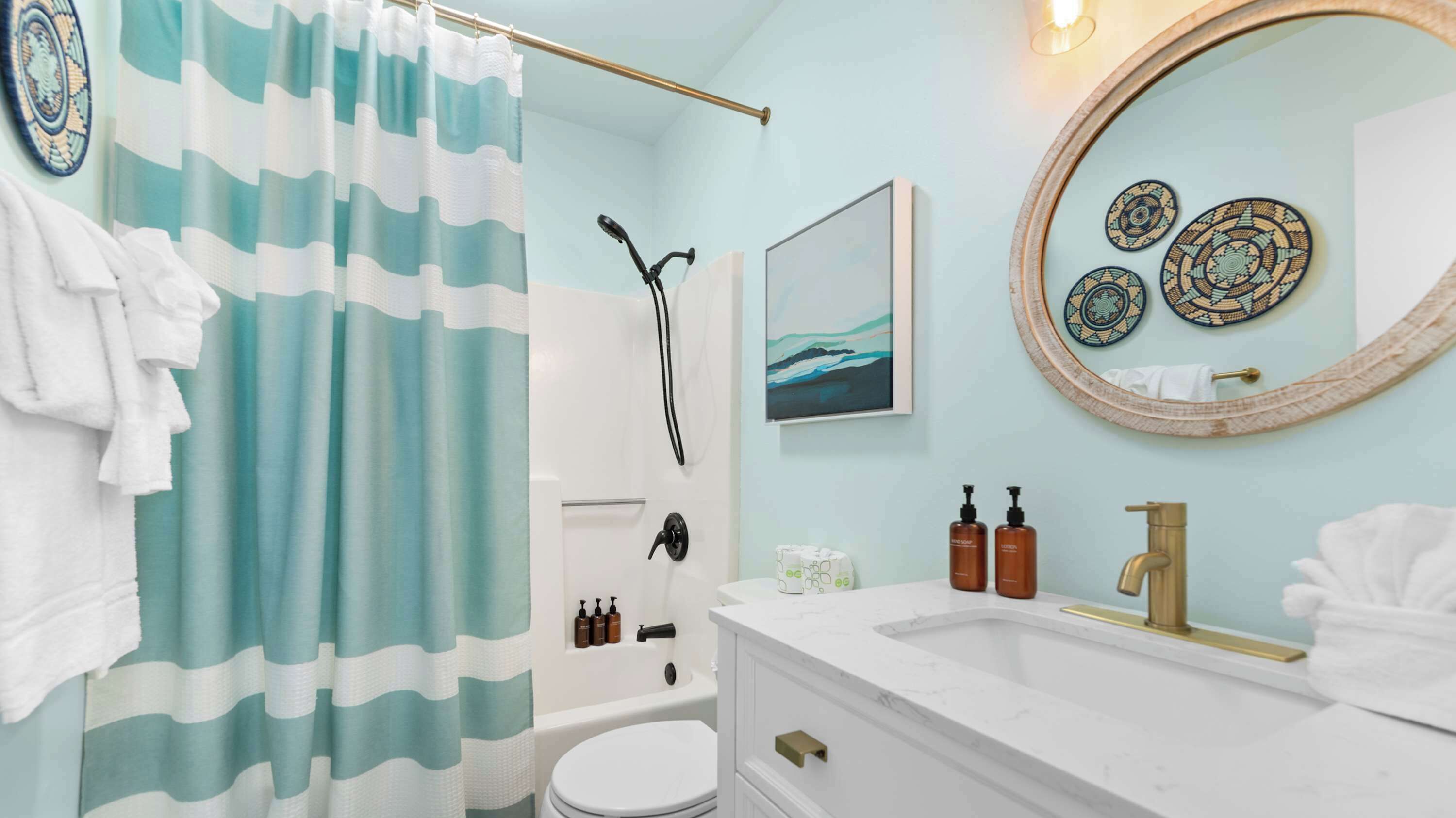 Un baño con ducha, inodoro, lavabo y toallero.