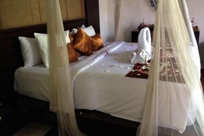 A bed with a canopy, pillows, and a decorative item on the side. - Aria Exclusive Villas & Spa (Bali)