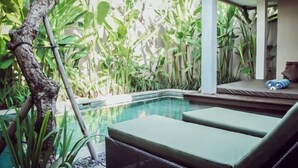 A pool area with lounge chairs and lush greenery. - Aria Exclusive Villas & Spa (Bali)