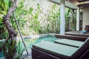 A pool area with lounge chairs and lush greenery. - Aria Exclusive Villas & Spa (Bali)