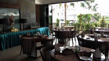 A restaurant with round tables, chairs, and a view of the outdoors.