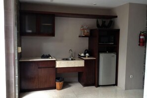 A compact kitchen with a refrigerator, sink, and cabinets. - Aria Exclusive Villas & Spa (Bali)