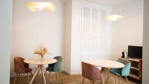 A dining area with a round table, four chairs, and two pendant lights. - Hostal Boutique La Malagueña Only Adults by Croma (Estepona)