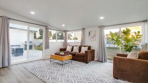 A spacious living room with a brown sofa, a wooden coffee table, and a patterned rug. - Family-Friendly Modern Escape in San Diego (San Diego)