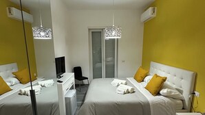 A hotel room with two beds, a desk, a chair, and a mirror. - Guest house with direct access to the beach (Portici)