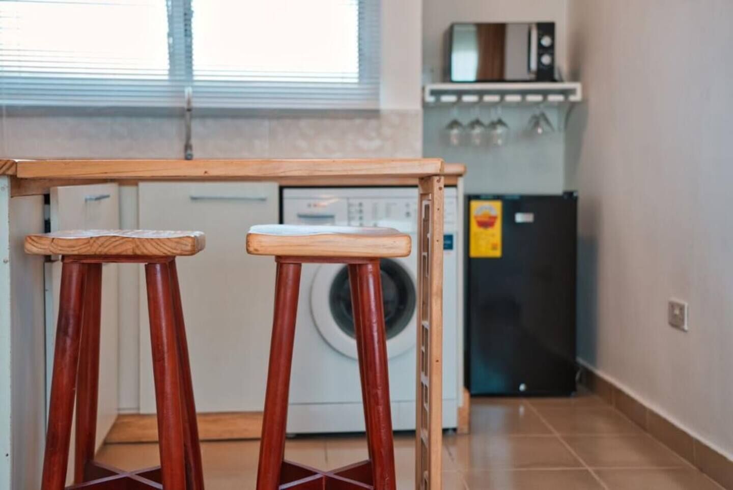 Une cuisine équipée d’un lave-linge, d’un four à micro-ondes et d’un réfrigérateur.
