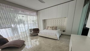 A modern bedroom with a large bed, a chair, and a desk. - Casa Lujosa, piscina, sala de cine y chimenea. Barrio mas cool del mundo (Medellín)
