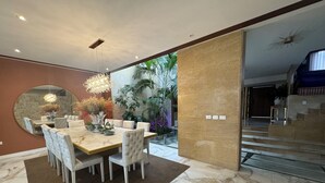 A modern dining area with a marble table and chairs, a large mirror, and a hanging light fixture. - Casa Lujosa, piscina, sala de cine y chimenea. Barrio mas cool del mundo (Medellín)