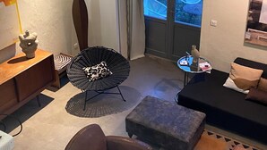 A modern living room with a sofa, armchair, and a small table. - Grand Loft Dartiste en Avec Équipement Professionnel Audio et Vidéo (Angoulême)