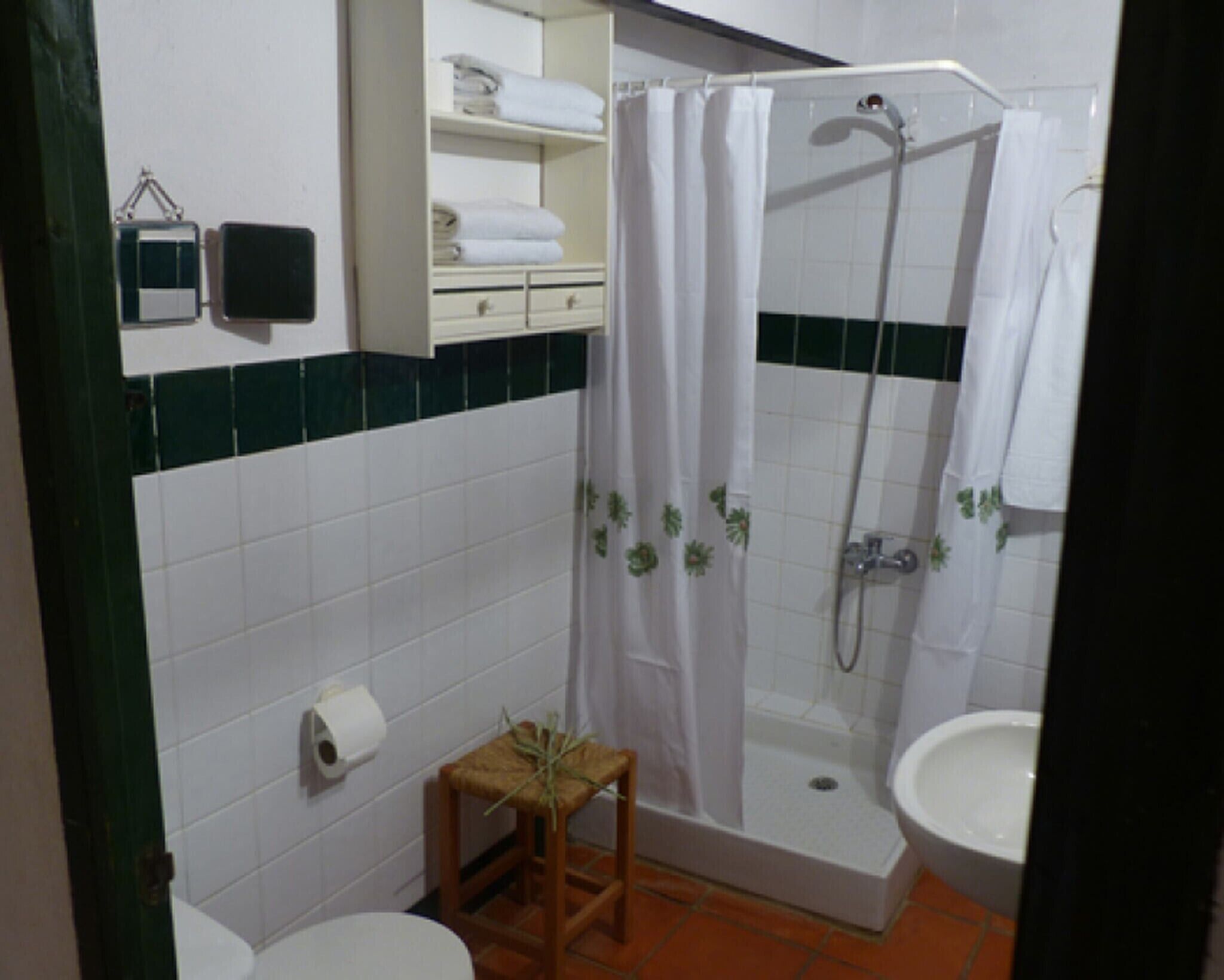 Un baño con ducha, inodoro y lavamanos.