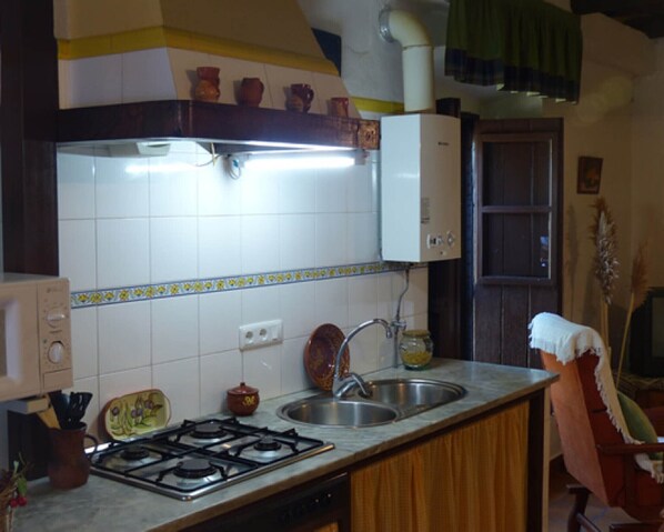 A kitchen with a stove, sink, and cabinets.