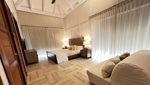 Een slaapkamer met een bed, nachtkastjes, een bank en een kledingkast.