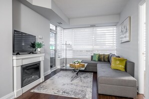 Relax in this stylish living room with a flat-screen TV, comfortable sofa, and glass coffee table.