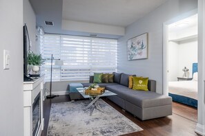 Relax in this stylish living room with a grey sofa, coffee table, and floor lamp, perfect for unwinding in comfort.
