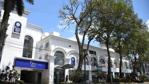 A white building with a blue sign for Lara Luna Hotel.