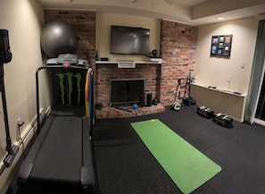 Stay fit on the go with a fully equipped home gym featuring a treadmill, stationary bike, and exercise equipment.