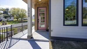 Una casa con una puerta rosa, un buzón y el número 2908 en un poste.