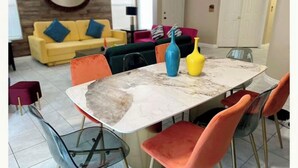 A dining area with a marble table, orange chairs, and colorful vases. - Bright, pet-friendly home near Summerlin and The Lakes (Las Vegas)