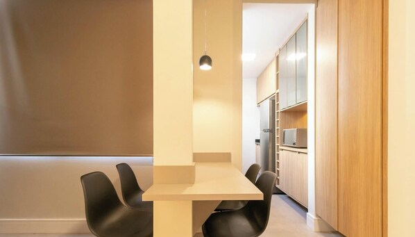 A modern kitchen with wooden cabinets and a built-in microwave.