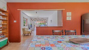 Una cocina con un piso de baldosas de colores, una mesa de comedor con sillas y un refrigerador.