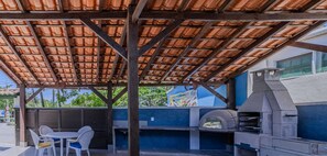 Enjoy casual dining and socializing in this outdoor patio area with a grill station and comfortable seating.