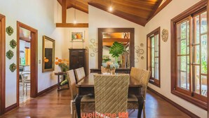 A spacious dining area with a wooden ceiling, large windows, and a central table with chairs. - Sitio em Indaiatuba com Piscina e Churrasqueira (Campinas)