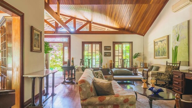 A spacious living room with a high wooden ceiling, large windows, and a sofa set. - Sitio em Indaiatuba com Piscina e Churrasqueira (Campinas)