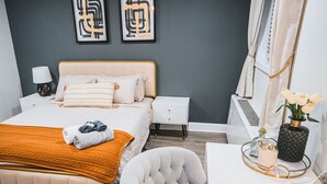 A bedroom with a bed, bedside tables, a chair, a desk, and a potted plant. - Unparalleled Convenience | City View | Food Scene (Atlanta)