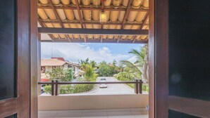 Uitzicht vanaf een balkon met betegelde vloer, houten balustrade en heldere lucht.