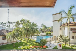 Zona residencial con piscina, palmeras y cielo despejado.