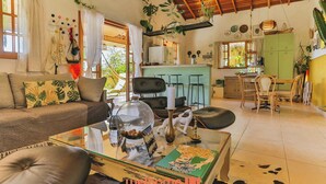 A cozy living room with a sofa, coffee table, and a dining area with chairs and a table. - Casa em Mairinque em meio a Natureza com Piscina (Mairinque)