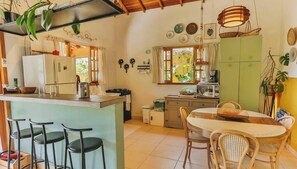 A cozy kitchen with a central island, bar stools, and a dining table with chairs.