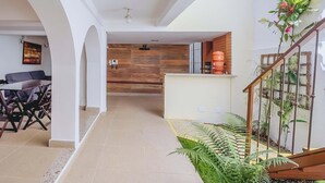 Un interior moderno con comedor, cocina y escalera.