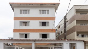 Un edificio de varios pisos con fachada blanca y bandas horizontales anaranjadas.