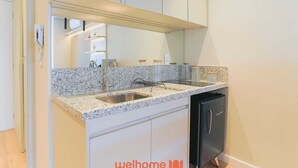A kitchen with granite countertops, a black refrigerator, and a white cabinet.
