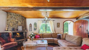 Una sala de estar acogedora con chimenea de piedra, sofás de cuero y una mesa de centro.