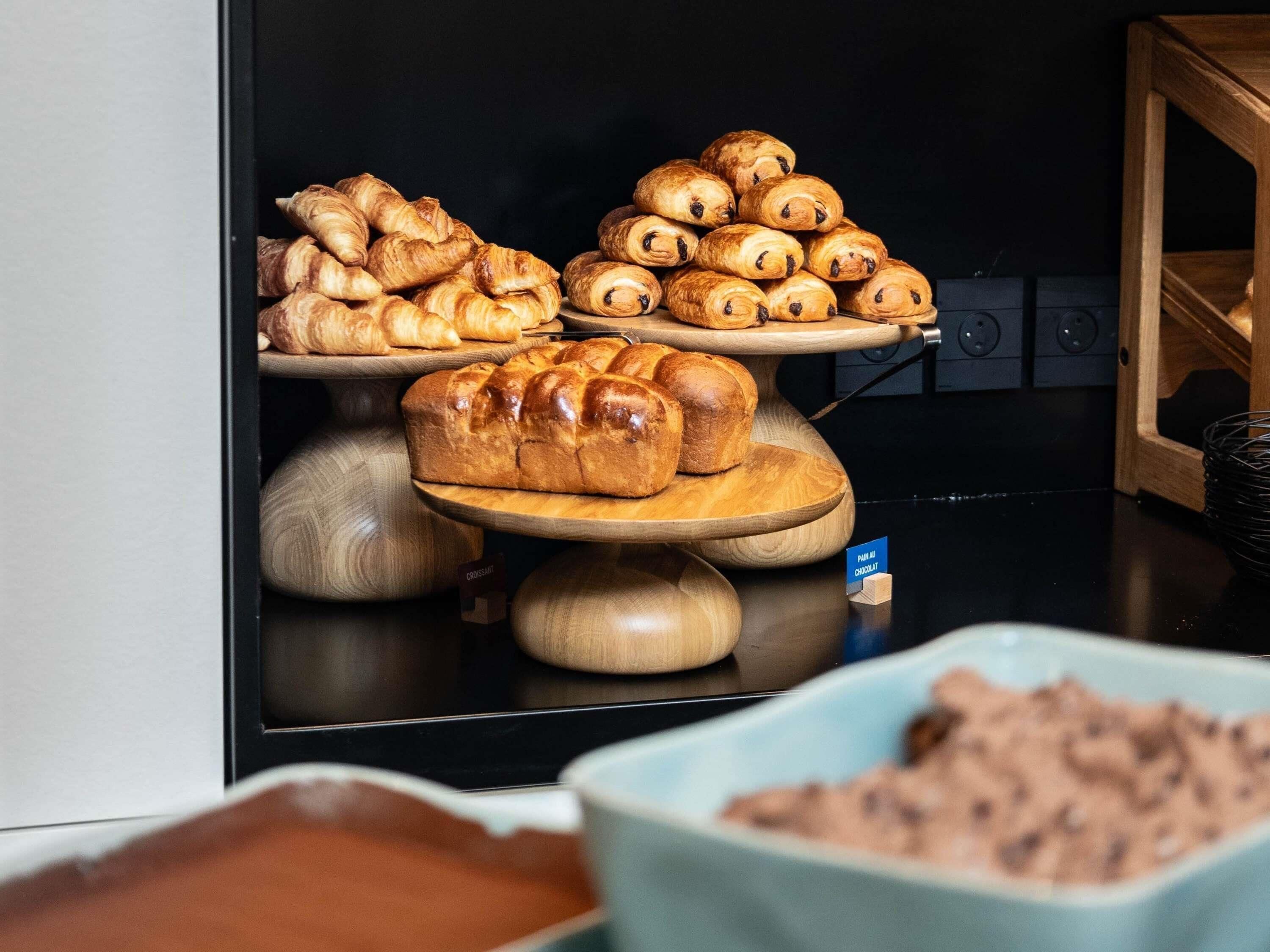 Une présentation de produits de boulangerie sur des présentoirs en bois, dans un décor de cuisine.