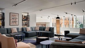 A modern living room with sectional sofas, a coffee table, and a bookshelf. - TRIBE Paris Pantin (Pantin)