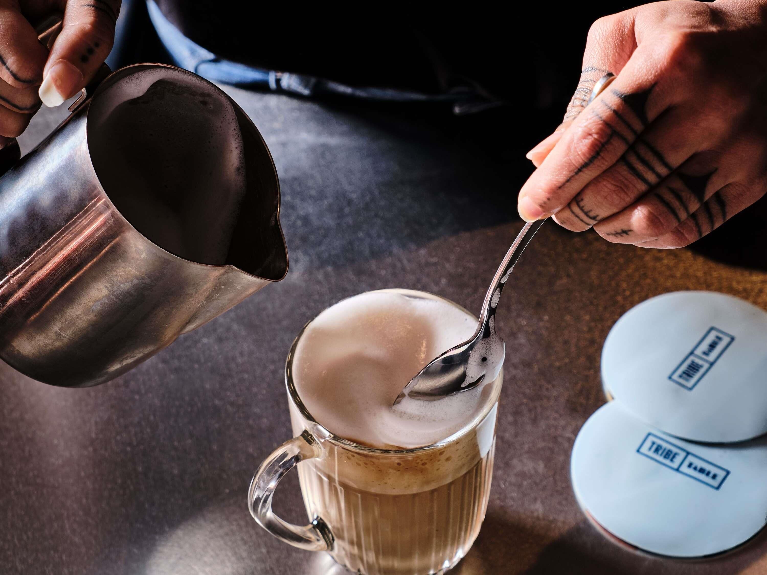 A person pouring a liquid into a glass mug.