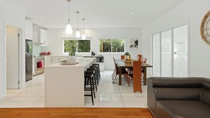 A modern kitchen with white cabinetry, a central island, and pendant lighting.